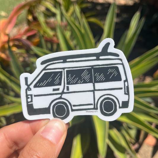 Black and white surf van sticker in front of green plants